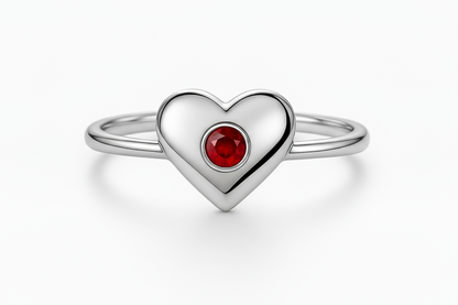Close-up of silver heart ring with red gemstone