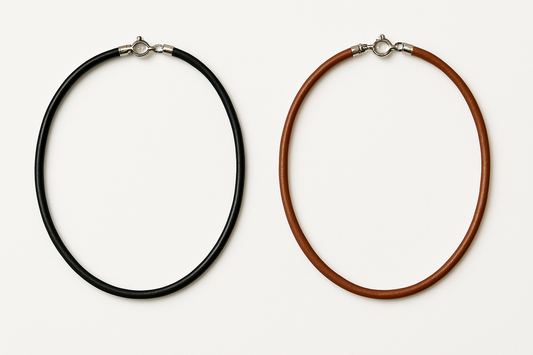 Two leather necklaces - black and brown with shiny silver clasps on white background